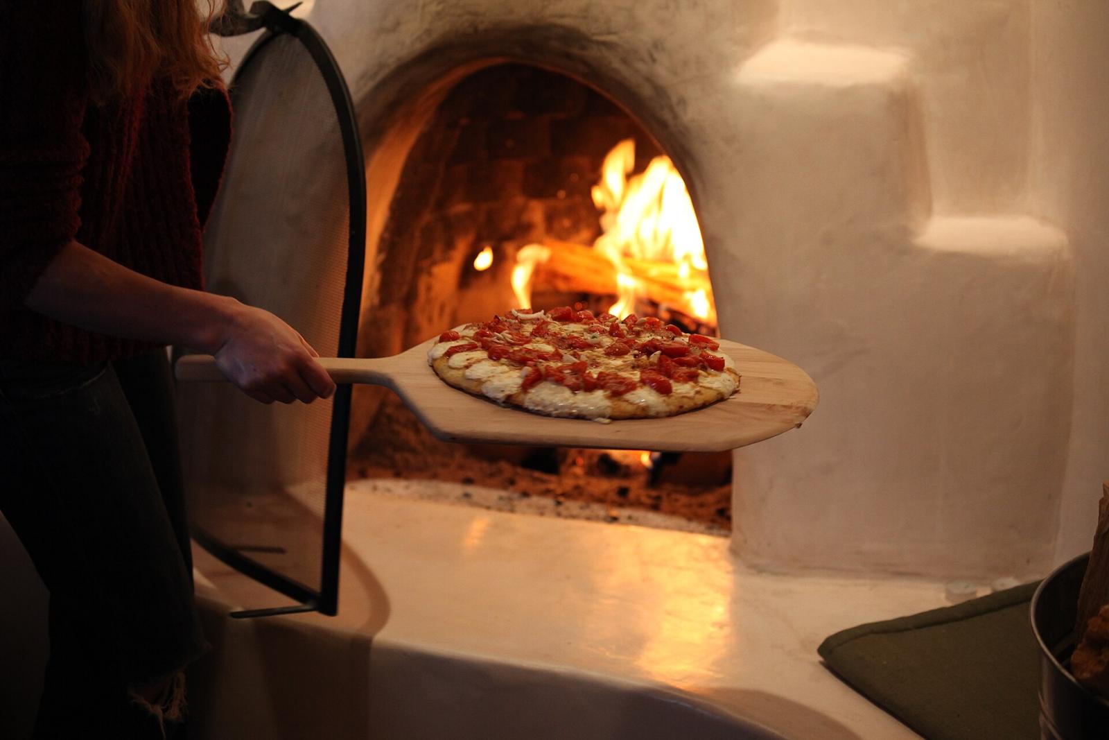 Il fondatore davanti al forno a legna con la pala